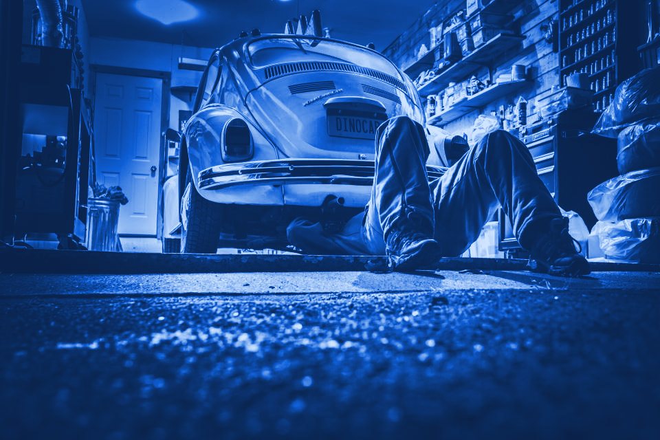 Atelier de garage — mécanicien au travail sur un véhicule